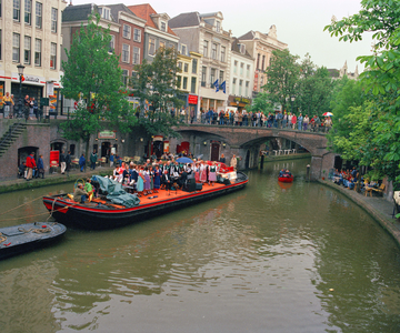 840364 Afbeelding van een zangkoor dat zingt op een 'muziekboot' op de Oudegracht tussen de Bezembrug en de ...